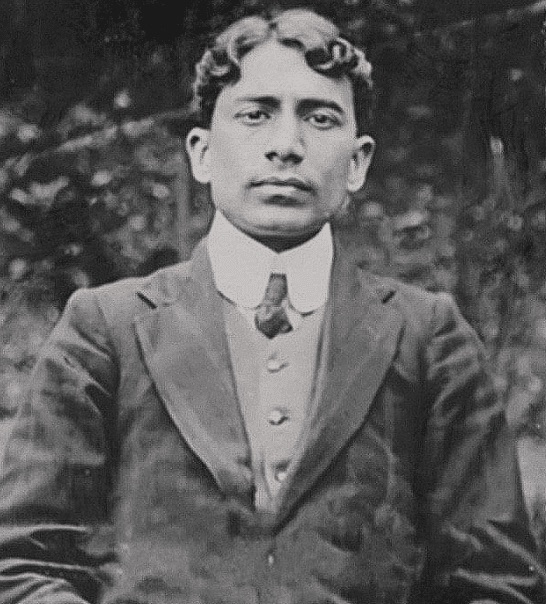 Photographic portrait of Madan Lal Dhingra as a young man, seated, wearing a dark jacket, waistcoat and high collar.